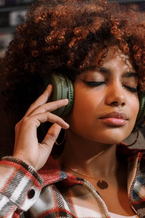 Woman with headphones enjoying music peacefully on balcony