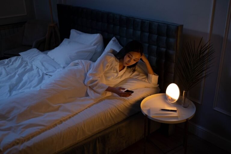 Woman in bed at night with phone showing sleep technology