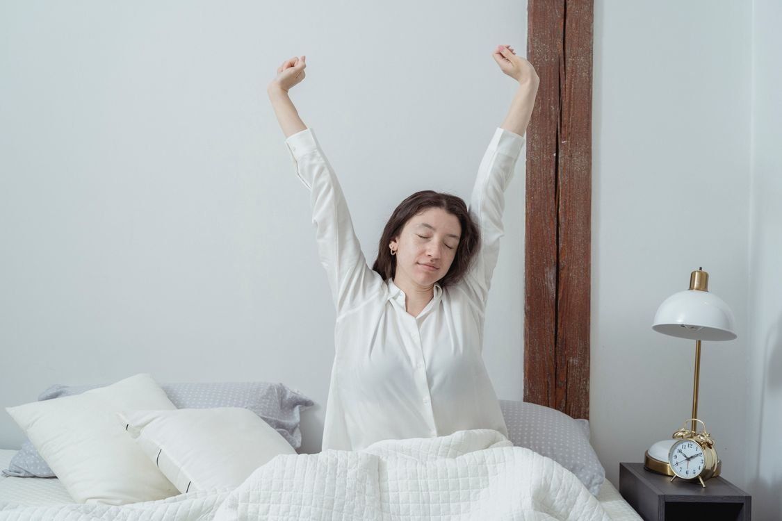 Woman stretching after waking up in the morning, representing morning recovery